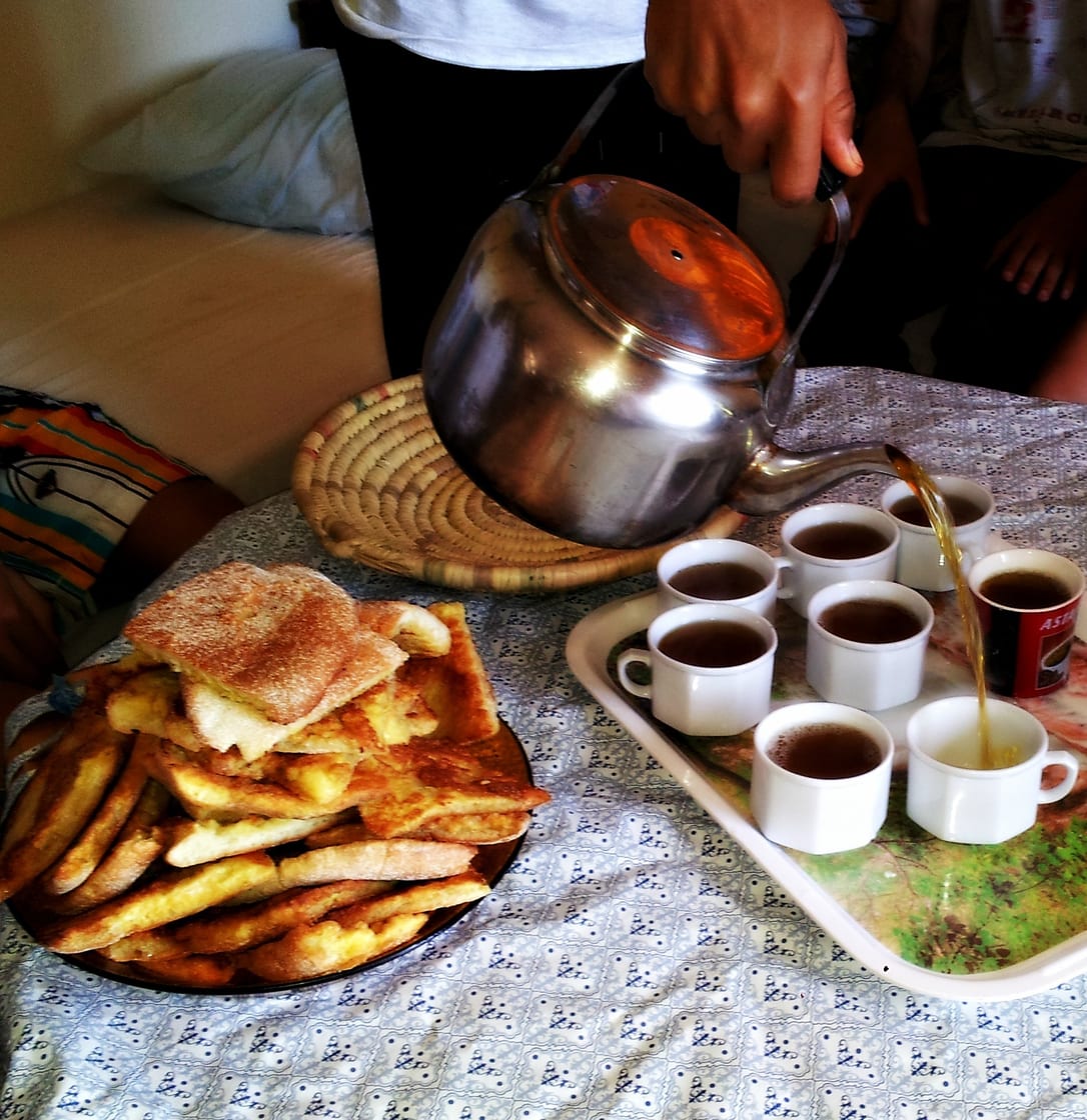 Le thé versé sur un plateau de verres, à côté d’une assiette de harcha